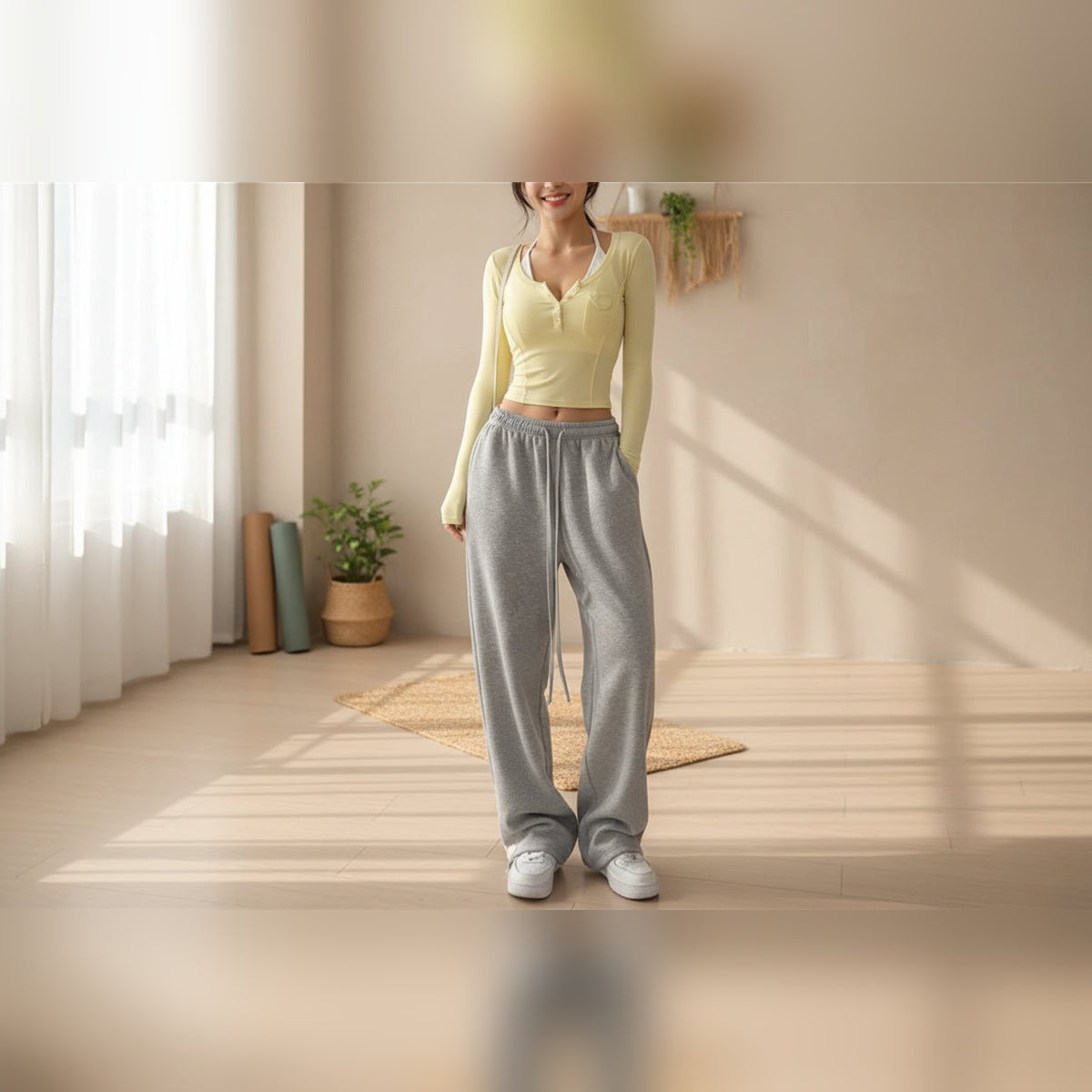 Calças Asari Light cinzento-claras largas com casaco amarelo numa sala – lifestyle