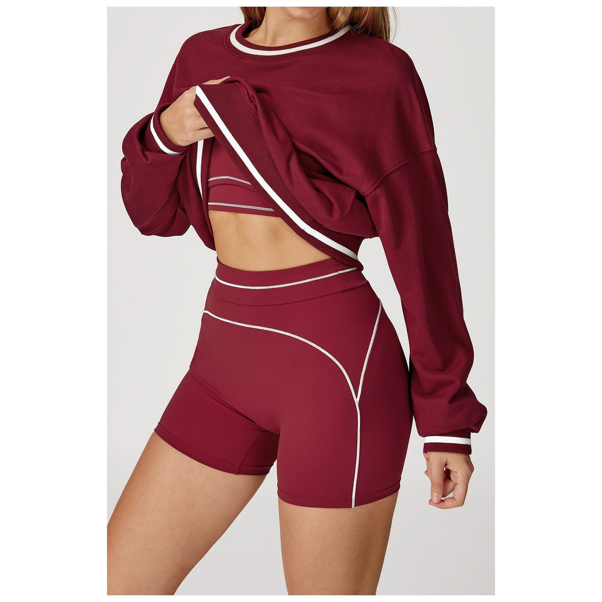 Camisola Shlama Ease vermelho-cereja levantada sobre top e calções – vista de frente