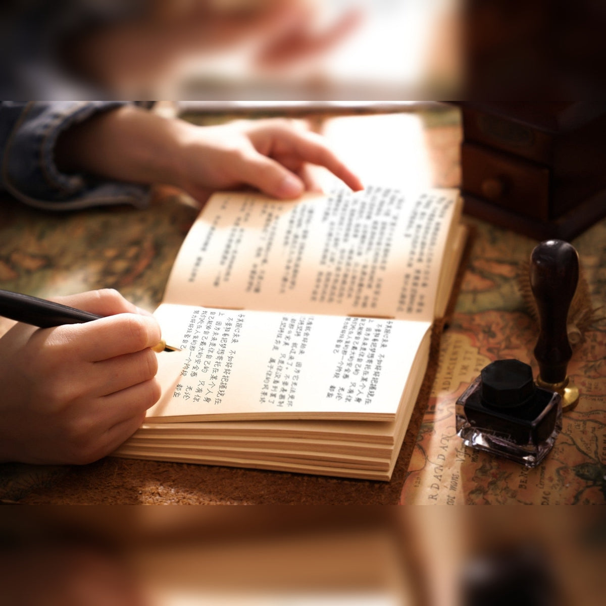 Mãos a escrever no caderno TerraLume aberto numa secretária – lifestyle