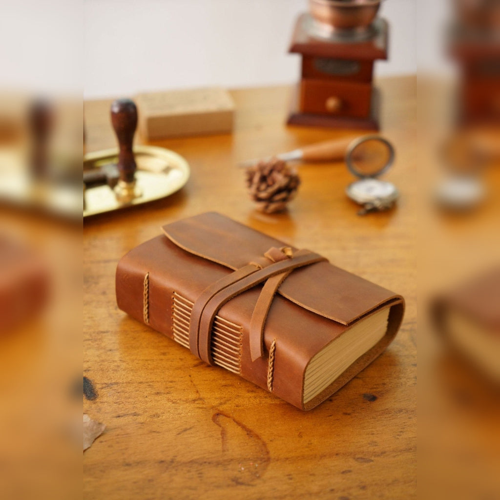 Caderno TerraLume em pele castanha numa secretária com carimbo – lifestyle