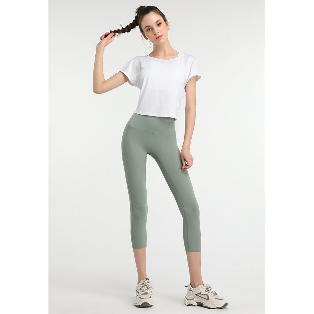T-shirt curta de yoga branca com leggings verdes – vista de frente
