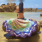Tapeçaria redonda Mandala Flow colorida com mulher sentada à beira-mar – lifestyle