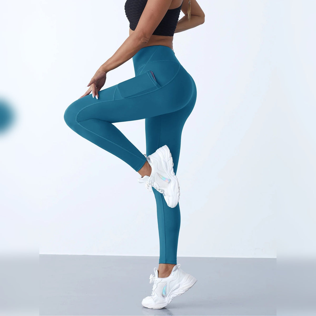 Leggings de yoga com bolsos azul-esverdeadas com perna dobrada – vista lateral
