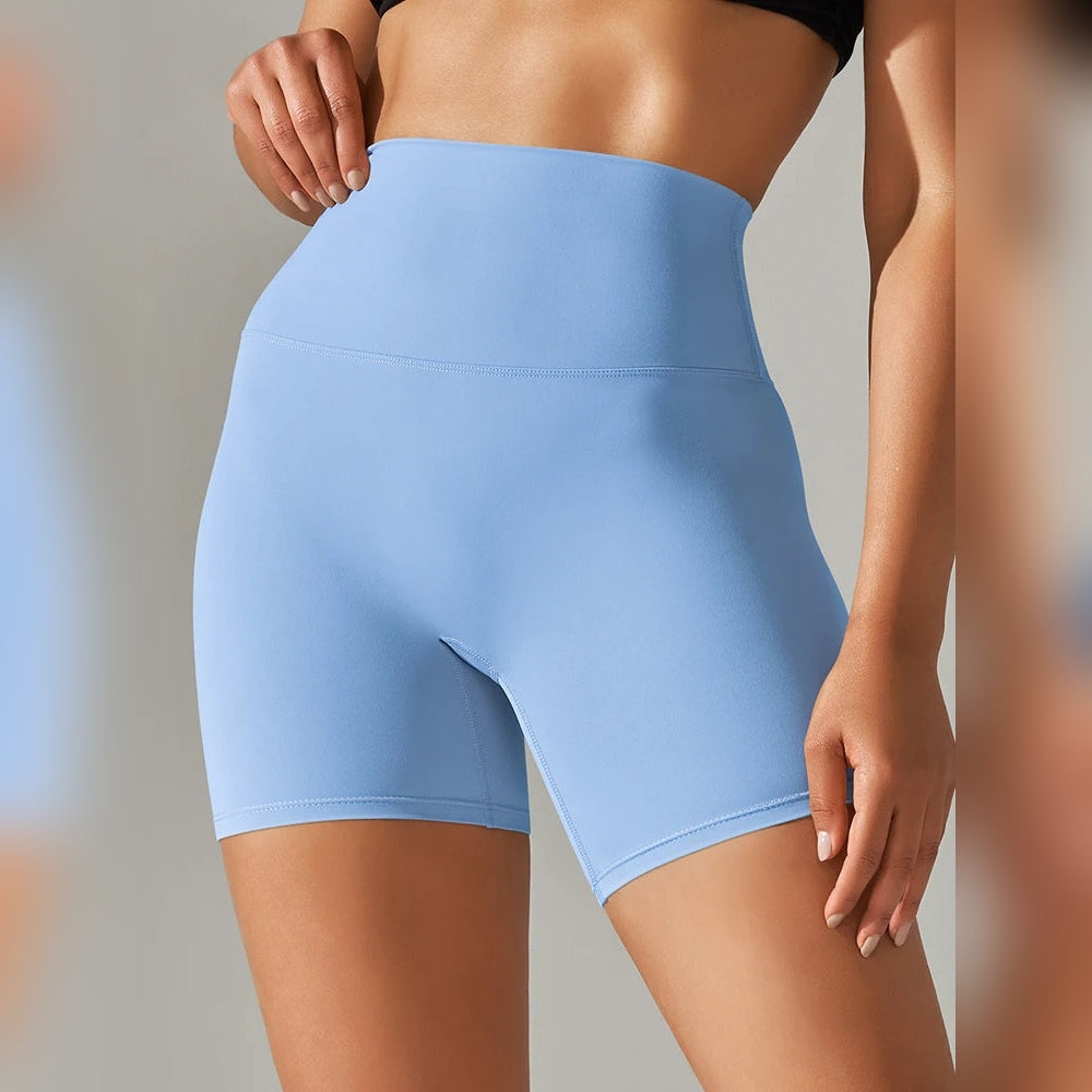 Calções Vita Motion azul claro numa modelo, vistos de frente, com cintura alta e cós largo.