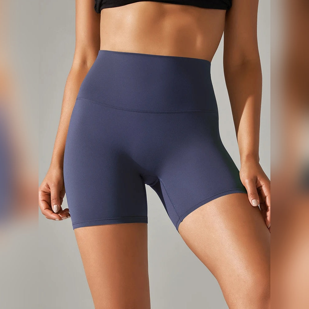 Calções Vita Motion azul escuro numa modelo, vistos de frente, com cintura alta e cós largo.