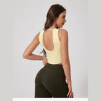 Top Sky Serenity amarelo com costas abertas e calças pretas – vista de costas