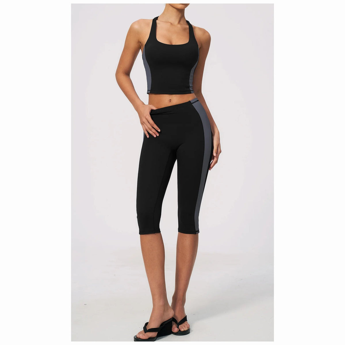 Conjunto Vinyasa Motion preto com top cavado e leggings capri – vista de frente