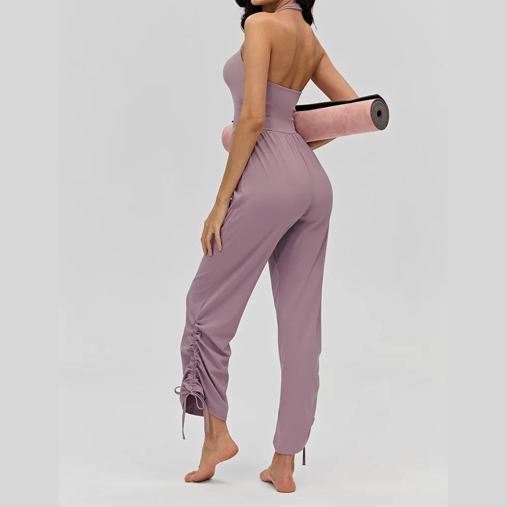 Macacão desportivo Devi roxo com franzido na perna e tapete na mão – vista de costas