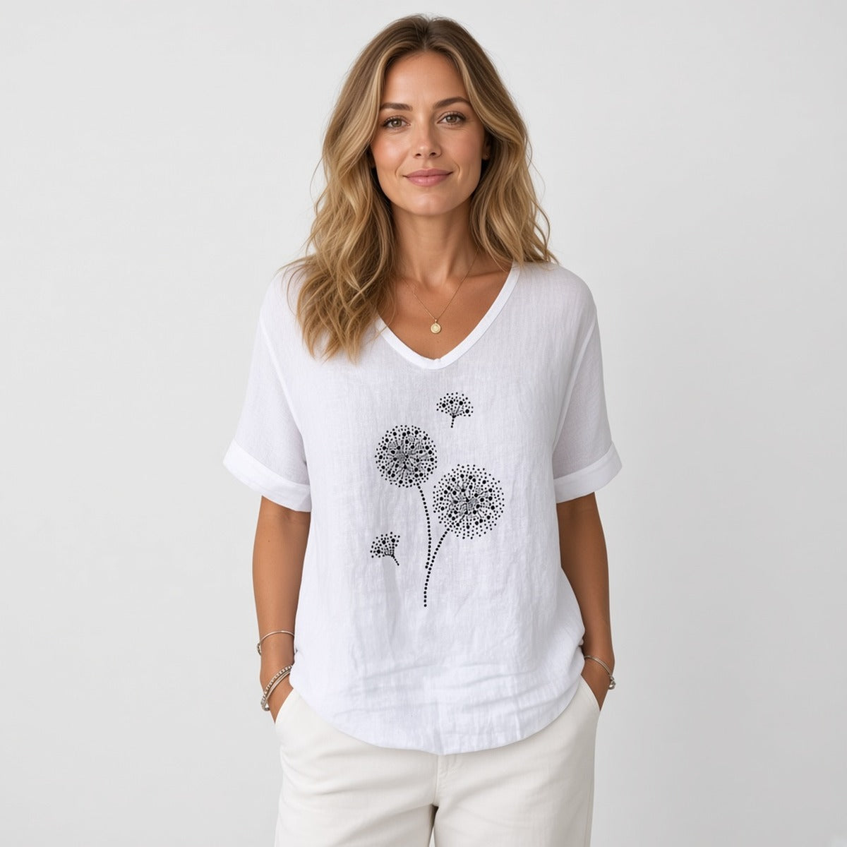 Aura Breeze Blouse – Leveza e Feminilidade – fotografia de estúdio, modelo com blusa branca de decote em V com estampa de dentes-de-leão