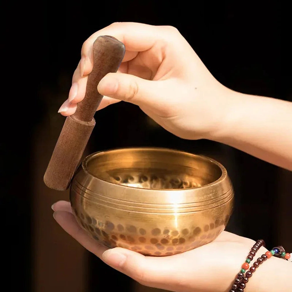 Como tocar a tigela tibetana Dhvani com a baqueta de madeira, pousada na palma da mão