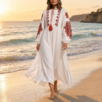 Mulher a passear na praia ao pôr do sol com o vestido boho Kalinda branco