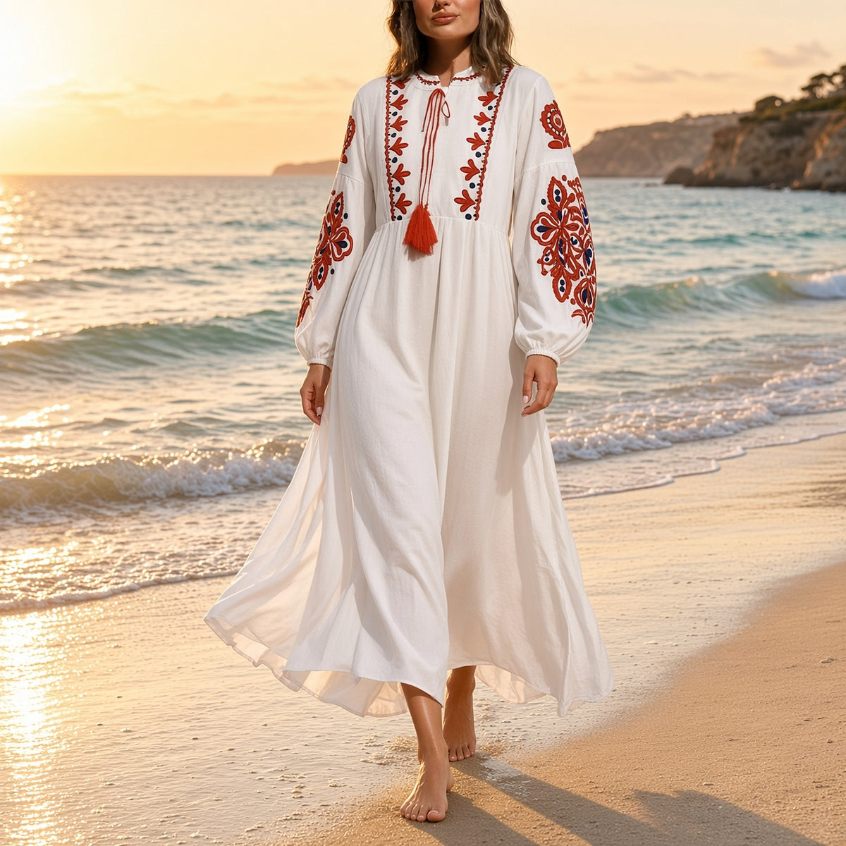 Mulher a passear na praia ao pôr do sol com o vestido boho Kalinda branco