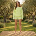Camisola Shlama Ease verde-lima em prática de yoga num jardim com oliveiras