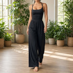 Macacão Solace preto num estúdio de yoga luminoso com plantas