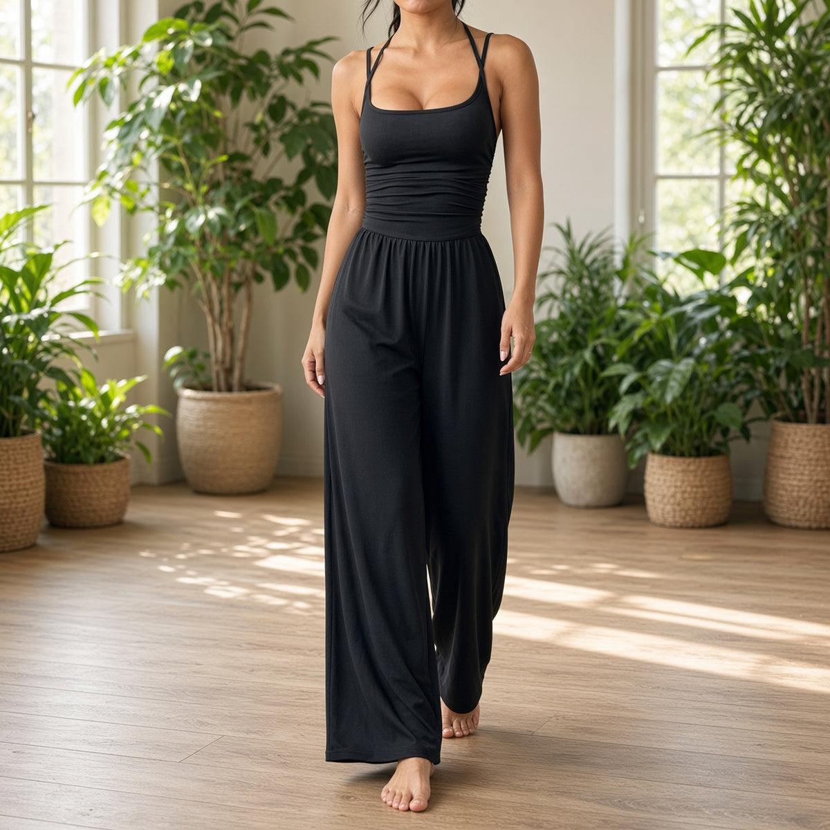 Macacão Solace preto num estúdio de yoga luminoso com plantas