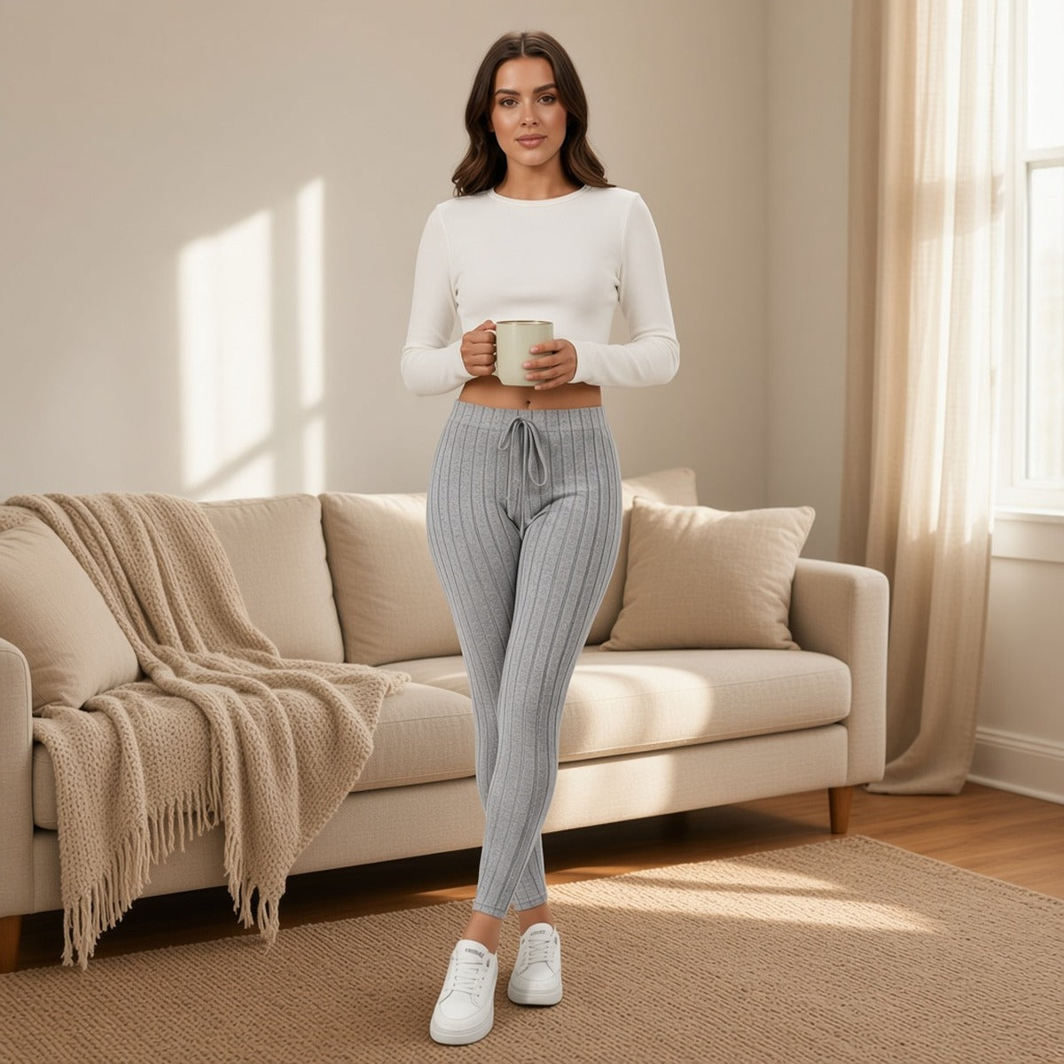 Leggings caneladas Ananda Daily cinzentas numa sala acolhedora com caneca na mão