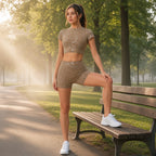 Conjunto Shakti Glow caqui com calções a alongar num banco de parque