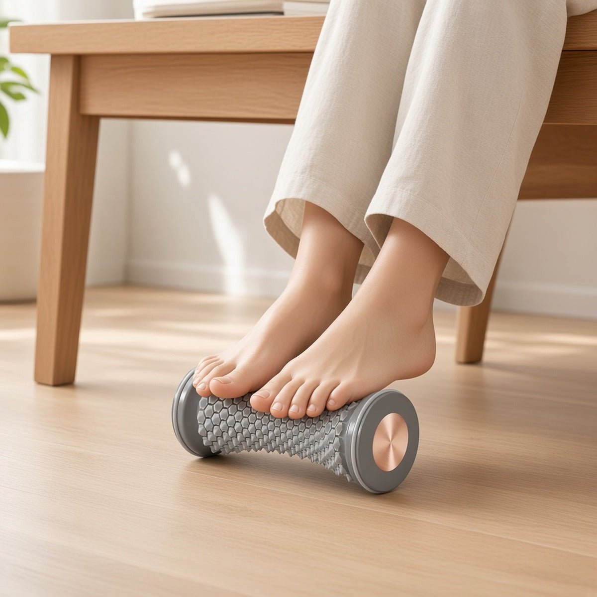 Rolo de massagem para pés Prana Roll cinzento sob os pés debaixo de uma secretária de madeira