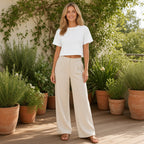 Pure Sky Tee – Luz e Simplicidade – lifestyle num terraço com plantas, t-shirt branca com calças de linho