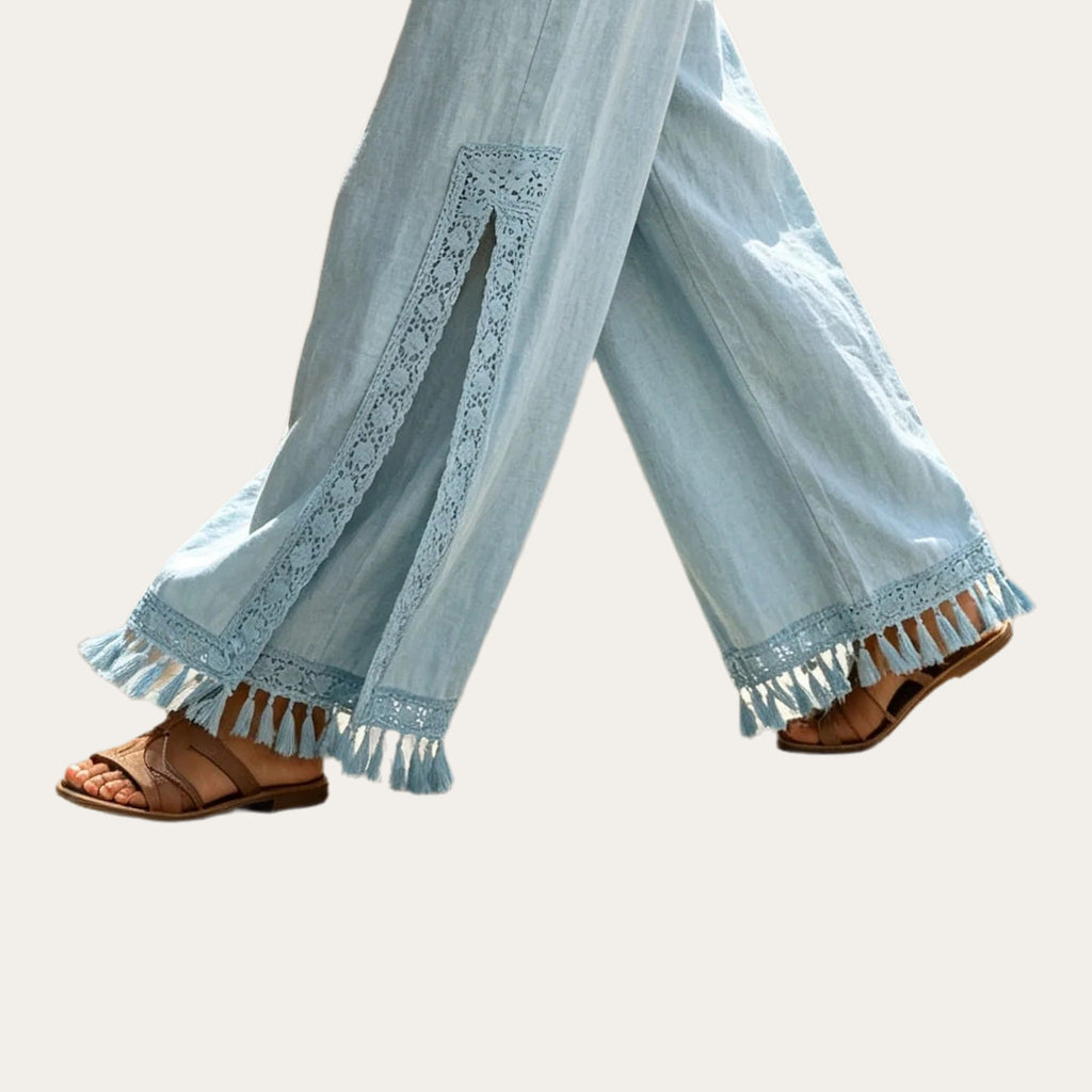 Nahar Bloom – Calças Fluidas de Perna Larga com Racha e Franjas, detalhe da renda vazada, da racha lateral e da bainha com franjas, cor Azul-Claro
