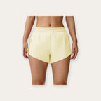 Idun Bloom – Calções plissados amarelo pastel fundo estúdio